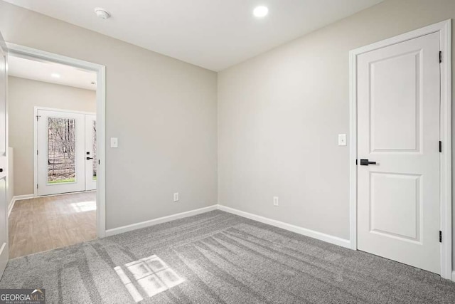 carpeted empty room featuring recessed lighting and baseboards