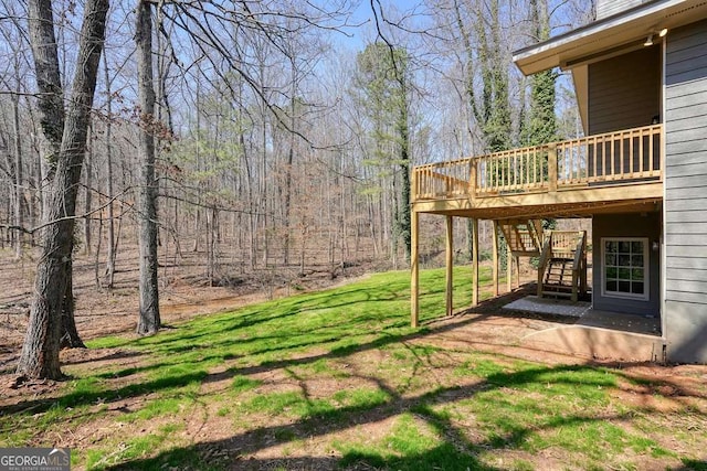 view of yard featuring a deck, a patio, and stairway