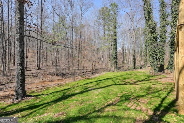 view of yard featuring a forest view