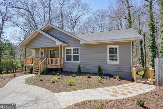 view of front of home with covered porch and a shingled roof