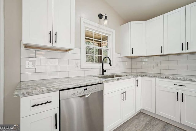 kitchen with a sink, backsplash, and stainless steel dishwasher