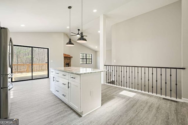 kitchen featuring visible vents, light wood-style flooring, freestanding refrigerator, and ceiling fan