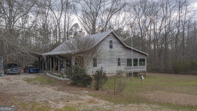 view of property exterior with dirt driveway and fence