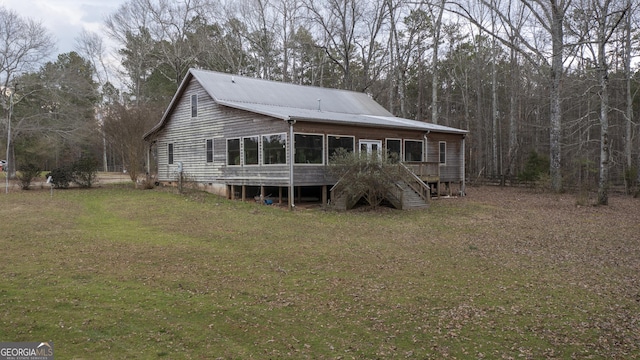 rear view of house with stairs and a yard