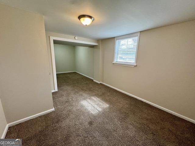 below grade area featuring carpet flooring and baseboards