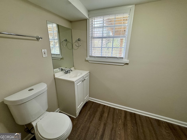 bathroom featuring vanity, toilet, wood finished floors, and baseboards