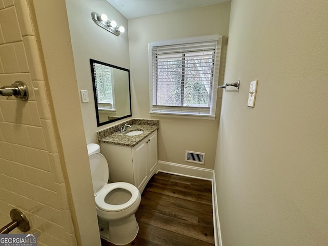 bathroom with vanity, wood finished floors, visible vents, baseboards, and toilet