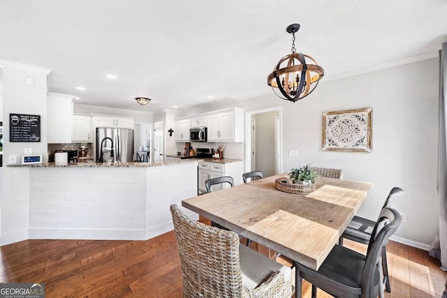 dining room featuring hardwood / wood-style floors, baseboards, recessed lighting, crown molding, and a notable chandelier