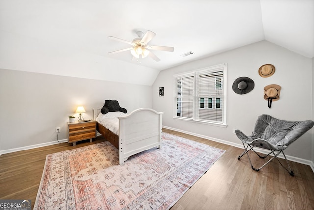 bedroom featuring lofted ceiling, wood finished floors, visible vents, and baseboards