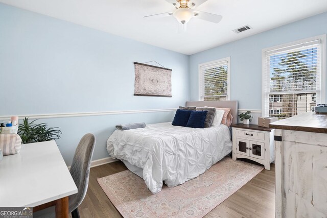 bedroom featuring visible vents, baseboards, light wood-type flooring, and a ceiling fan