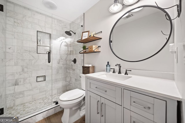 full bathroom with visible vents, a shower stall, toilet, wood finished floors, and vanity