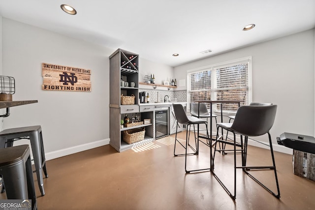 home office featuring visible vents, baseboards, concrete floors, recessed lighting, and indoor wet bar