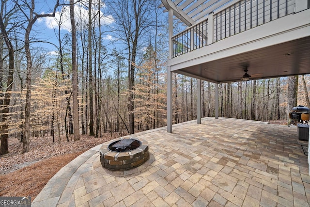 view of patio with a balcony, a grill, an outdoor fire pit, and ceiling fan