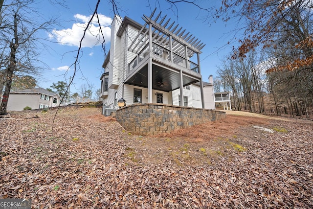 rear view of house with a balcony and ceiling fan