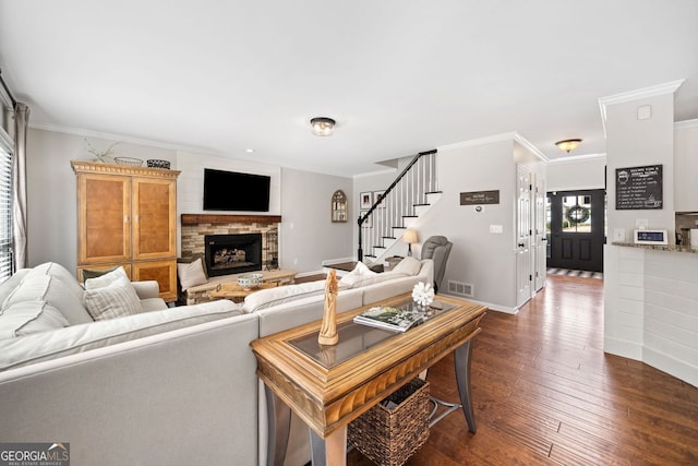 living room featuring stairway, dark wood-style floors, visible vents, and ornamental molding