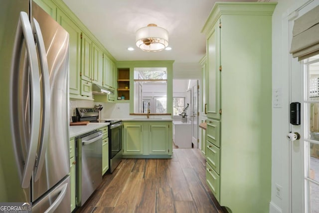 kitchen featuring green cabinetry, a sink, light countertops, dark wood-type flooring, and appliances with stainless steel finishes