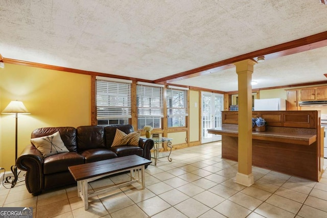 living area with light tile patterned floors, a textured ceiling, baseboards, and decorative columns