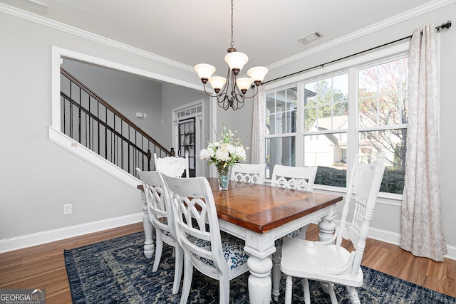 dining space with ornamental molding, wood finished floors, visible vents, and baseboards