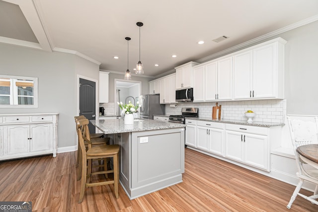 kitchen featuring white cabinets, light wood finished floors, visible vents, and appliances with stainless steel finishes