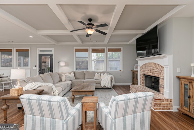 living room featuring baseboards, coffered ceiling, and wood finished floors