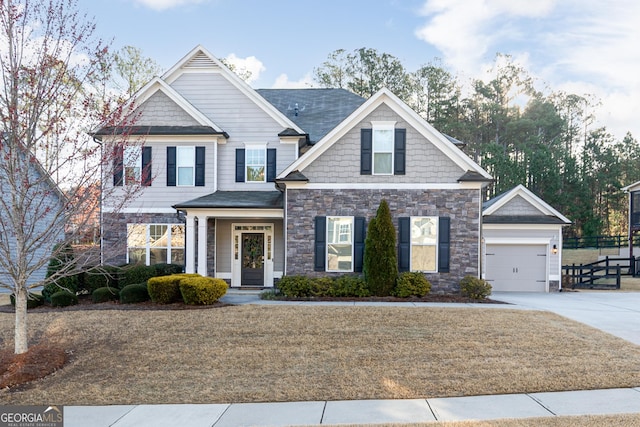 craftsman house featuring a garage, stone siding, and concrete driveway