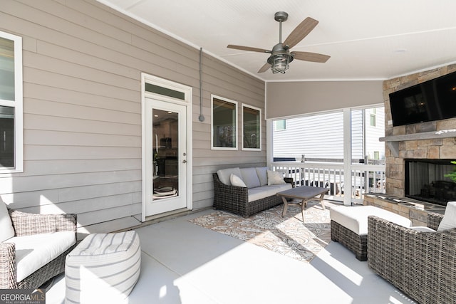 view of patio with an outdoor living space with a fireplace and ceiling fan