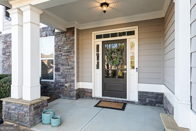 entrance to property featuring stone siding and covered porch