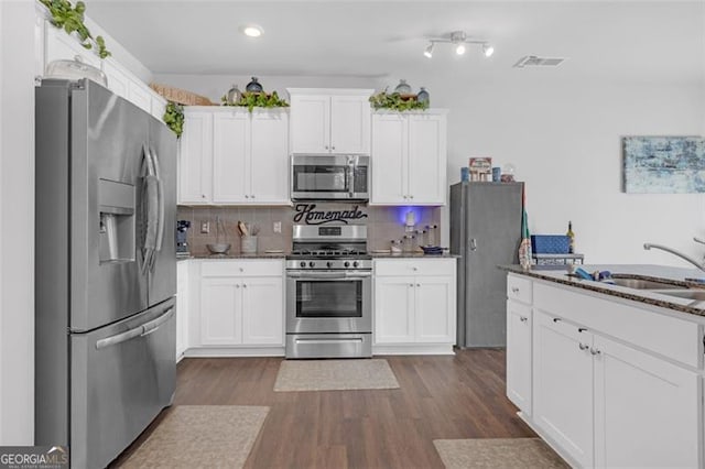 kitchen featuring tasteful backsplash, appliances with stainless steel finishes, dark wood finished floors, and white cabinetry