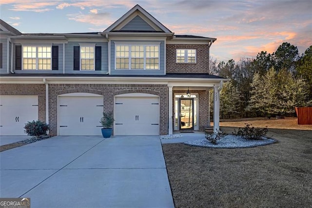 view of front of house with brick siding, a garage, and driveway