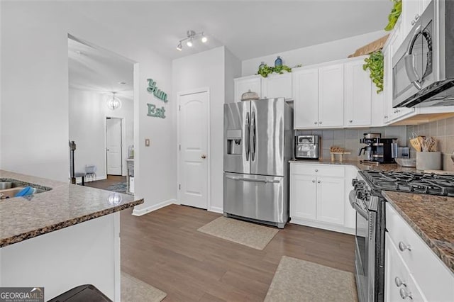 kitchen featuring stainless steel appliances, backsplash, dark wood finished floors, and white cabinets