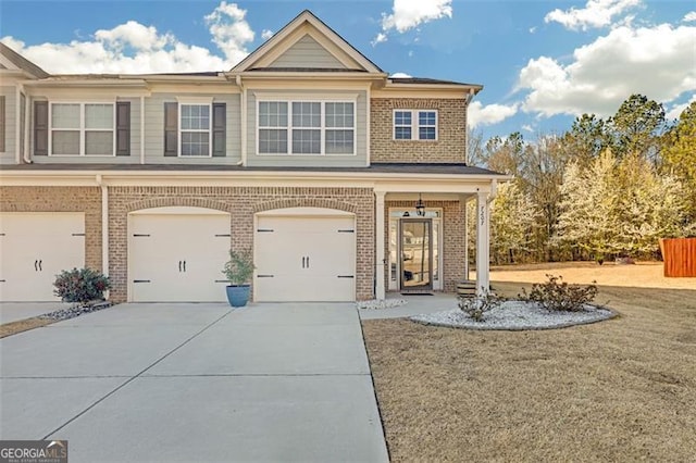 view of front of home featuring brick siding, an attached garage, and driveway