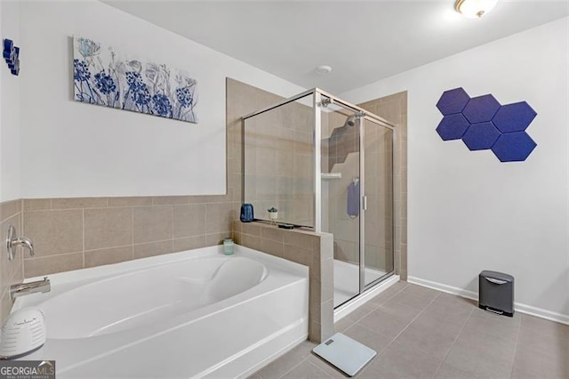 bathroom with tile patterned floors, a bath, baseboards, and a stall shower