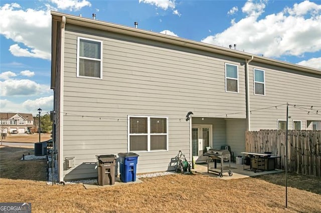 rear view of property with a patio area, a lawn, and fence