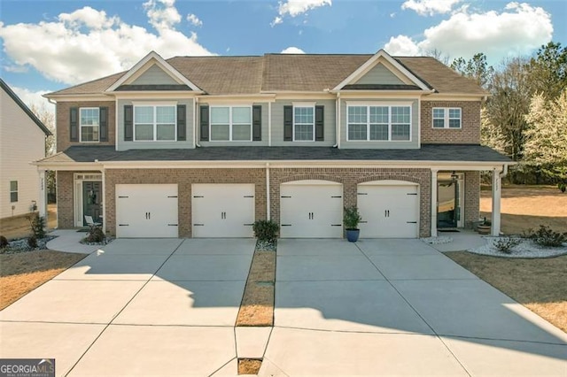 view of property featuring concrete driveway, brick siding, and a garage