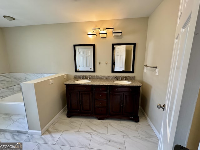 bathroom with a sink, marble finish floor, a tub, and double vanity