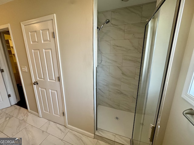 full bathroom featuring baseboards, marble finish floor, and a stall shower