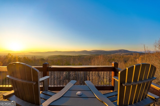 deck at dusk featuring a mountain view