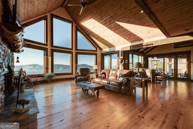 living area with hardwood / wood-style floors, wooden ceiling, a healthy amount of sunlight, and high vaulted ceiling