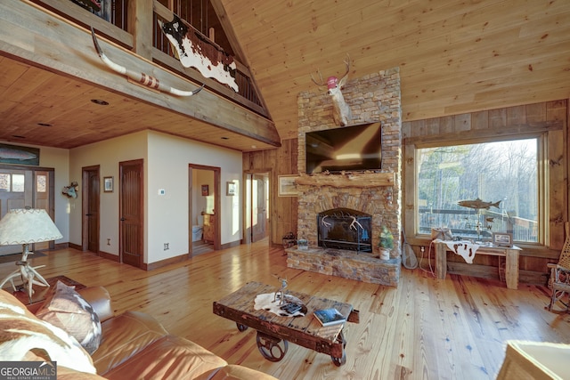 living area with a stone fireplace, wooden ceiling, high vaulted ceiling, and wood-type flooring