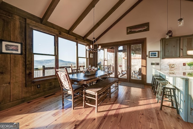 dining room with high vaulted ceiling, a mountain view, beamed ceiling, a notable chandelier, and light wood-type flooring