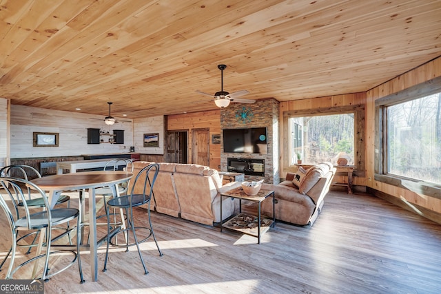 living room with wooden walls, a fireplace, and wood ceiling