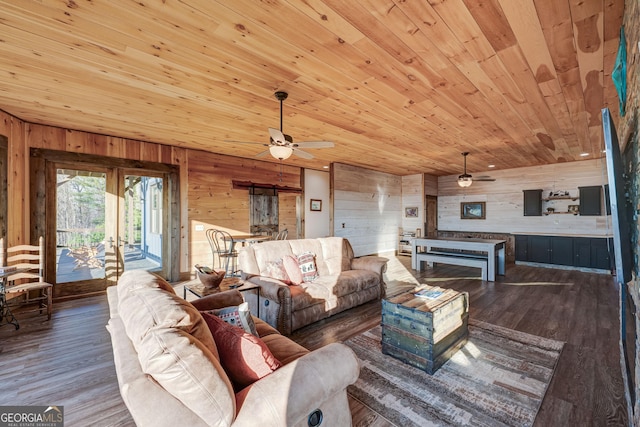 living area featuring wooden walls, wooden ceiling, and wood finished floors