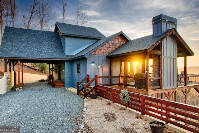 rustic home with a shingled roof, board and batten siding, and a chimney