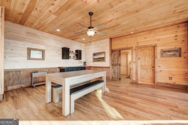 dining room featuring light wood finished floors, ceiling fan, wood walls, recessed lighting, and wooden ceiling