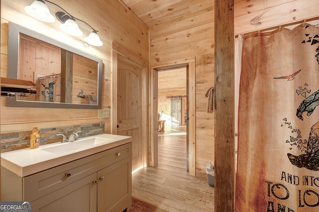 bathroom with wood finished floors, wood ceiling, wood walls, and vanity