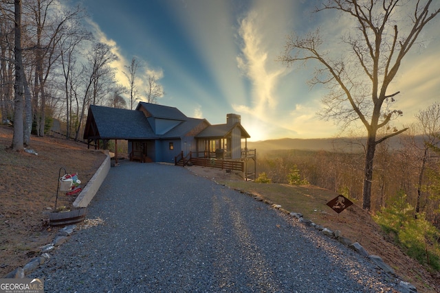 view of front of home with a porch and gravel driveway