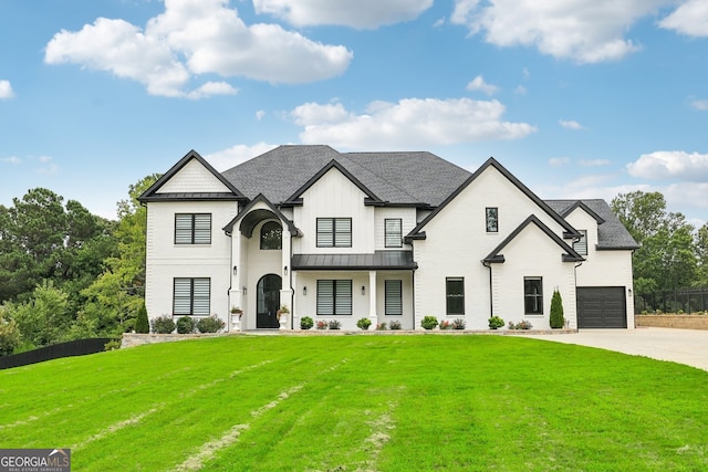 view of front facade with a front lawn, a standing seam roof, concrete driveway, a shingled roof, and metal roof