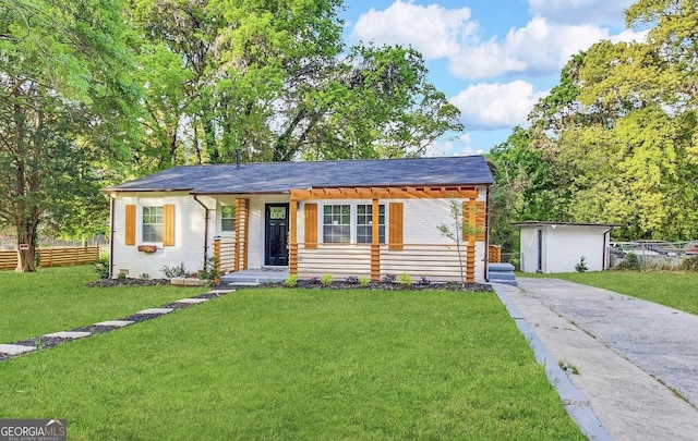 ranch-style home featuring a front yard, fence, brick siding, and driveway