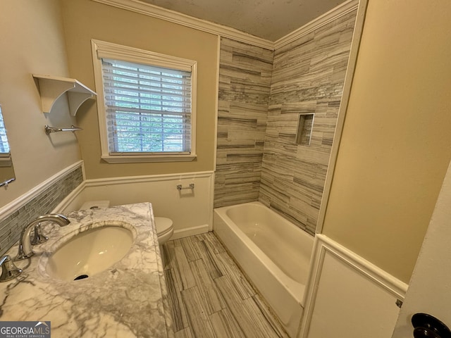 full bath featuring vanity, bathing tub / shower combination, wood tiled floor, crown molding, and toilet