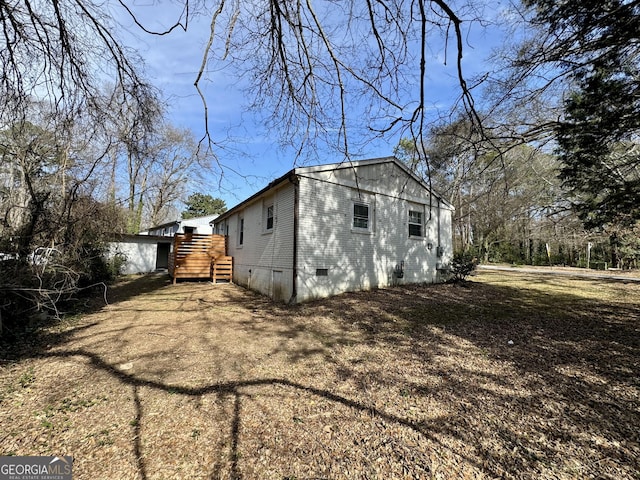 view of side of property featuring brick siding and crawl space